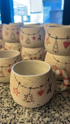 many cups are lined up on the counter with clothes pins and hearts painted on them