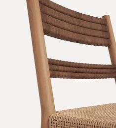 a close up of a wooden chair with wicker on the back and seat cushion