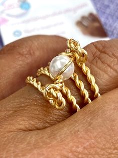 "Beautiful and unique Pearl Gold Wire Wrapped Ring, ideal for an special gift for her, it's very elegant and will make her get many compliments.  This ring is made with a 6mm round pearl and wrapped in non tarnish gold wire. It is made to order in the size of your choice.  I T E M ~D E T A I L S Materials: Gold Plated Twisted Wire, Swarovski 6mm Pearls. Size: See Variations. Thank you for visiting my product. You can see more amazing designs in my shop clicking here: https://www.etsy.com/shop/Na Elegant Hand Wrapped Rings For Anniversary, Elegant Gold Hand Wrapped Rings, Handmade Gold Pearl Promise Ring, Elegant Wire Wrapped Toe Rings, Wire Wrapped Pearl Wedding Ring, Elegant Adjustable Wire Wrapped Pearl Ring, Elegant Adjustable Hand-wrapped Rings, Adjustable Gold Pearl Promise Ring, Elegant Handmade Adjustable Pearl Ring