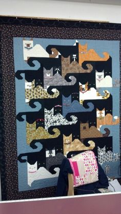 a quilted wall hanging with cats on it