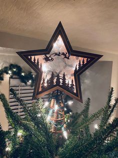 a star shaped christmas tree topper hanging from the ceiling