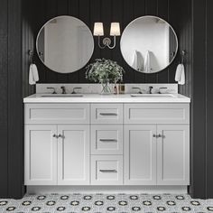 a bathroom with two sinks and mirrors on the wall next to black painted wood paneling