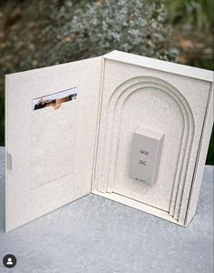 an open white album with pictures inside