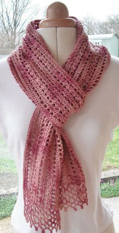 a pink crocheted scarf on top of a mannequin headdress