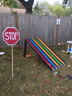 a yard with a stop sign and several colored pencils on the ground in front of it