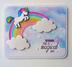 a card with a unicorn on top of a rainbow and clouds in the background that says wishing you a magical day