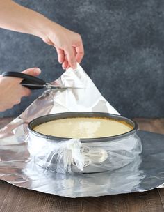 someone is cutting into a cake in a pan