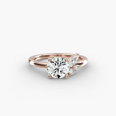 a rose gold engagement ring with three stones on the side and an oval diamond in the center