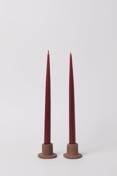 two red candles sitting on top of each other