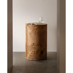 a book is sitting on top of a wooden table next to a wine glass holder