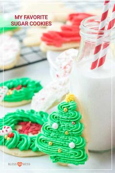 cookies decorated to look like christmas trees are next to a bottle of milk with a straw in it