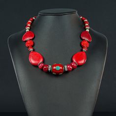 This unusual red Necklace is 20 1/4" long made with a Tibetan oval centerpiece of Enamel and Turquoise (30x20mm) framed with 4 faceted red Jade rondels, red  Howlite ovals and hearts and Tibetan red , silver ended 9mm decorative beads to frame the Sterling lobster clasp (10x20mm) Red Coral Necklaces As Gifts, Handmade Oval Beads Red Coral Jewelry, Handmade Red Coral Oval Beads Jewelry, Handmade Red Coral Jewelry With Oval Beads, Red Polished Beads Round Jewelry, Red Coral Jewelry With Natural Stones, Red Gemstone Necklace For Valentine's Day, Handmade Red Oval Necklace, Handmade Red Necklaces For Valentine's Day