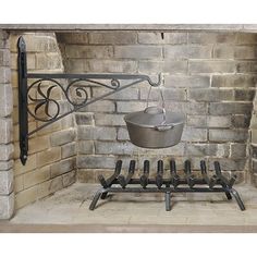 an old brick fireplace with a pot and pan on the fire grate next to it