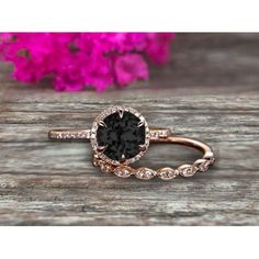 an engagement ring with a black diamond in the center on top of a wooden table