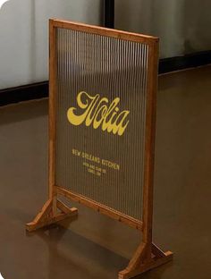 a wooden sign sitting on top of a hard wood floor