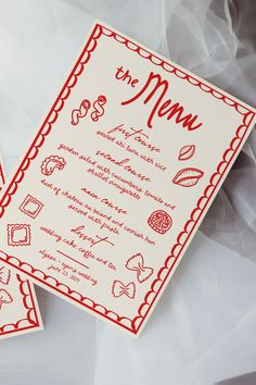 two wedding cards with red ink on them