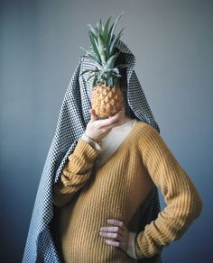 a woman with a pineapple on her head is wearing a blanket over her head