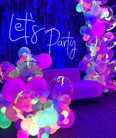 balloons and streamers in front of a party sign