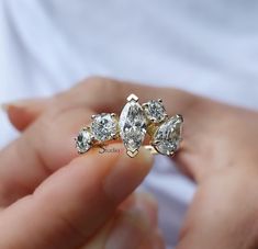 a woman holding three diamond rings in her hand