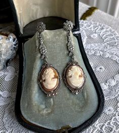 Featuring a gorgeous pair of antique 1910s-20s Edwardian Belle Époque rhodium plated screw back drop  earrings adorned with luminous genuine carved conch shell cameos set in decorative open back pronged settings.  These beauties are in excellent condition with  a lovely patina with all stones intact and accounted for.  Earrings measure approximately 2  inches long at 7.7  grams respectively.  Beautifully designed and handcrafted, elegant and sophisticated! Please feel free to contact me with any Victorian Dangle Earrings For Vintage Events, Victorian Drop Earrings For Vintage Events, Nickel-free Antique Silver Jewelry, Vintage Sterling Silver Jewelry For Vintage Events, Sterling Silver Vintage Jewelry For Vintage Events, Sterling Silver Vintage Jewelry For Events, Antique Silver Vintage Dangle Jewelry, Vintage Antique Silver Dangle Jewelry, Vintage Hallmarked White Gold Earrings