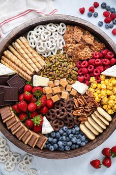 a wooden platter filled with fruit and snacks