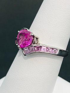 This striking heart shape pink cubic zirconia ring is handmade in sterling silver and is complete with princess cut light powder pink cubic zirconias and two natural white diamond accents. The vibrancy of the center stone will make your mouth water! The design was meticulously thought out as it includes two hearts on each side of the ring in filigree metal work. Can be sized up or down for an additional charge. Feel free to contact us with any questions you may have. Dazzling Pink Sterling Silver Ring, Fine Jewelry With Cubic Zirconia And Side Stones, Pink Sterling Silver Diamond Ring With Accent Stones, Pink Sterling Silver Diamond Ring With Vs Clarity, Pink Diamond Ring With Vs Clarity In Sterling Silver, Pink Diamond Ring In Sterling Silver With Vs Clarity, Pink Diamond Promise Ring In Fine Jewelry Style, Pink Sapphire Ring With Center Stone In Sterling Silver, Pink Sterling Silver Rings With Accent Stones