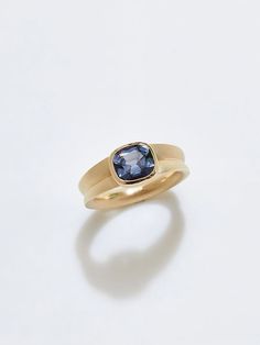 a yellow gold ring with a blue stone