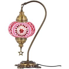 a pink and gold lamp with a star on the bottom is sitting on a white surface