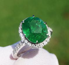 A Breathtakingly Striking HANDMADE 14k White Gold Ring with Beautiful Oval Cut Tsavorite in Green color! The GEM is 7.20CT and measures 12.00x9.93x7.04 mm! This Stone will take your breath away, especially on the sunlight! You will want to look at this stone endlessly. The mounting is a masterpiece! HANDMADE 14K White Gold Diamond Mounting (tested), that was is custom made to Accommodate this Beauty of a Gem in a V-prongs setting! Super FINE Workmanship on the Diamond v-split setting with 32 pcs Brilliant Full Cut Diamonds in GH color, SI1 clarity, totaling to approx  0.53 ct! Fabulous Braided Band and Diamond Gallery! The Entire Top's outline is 14.6x13.3 mm- HUGE. The Ring weights 5.6g, nice and SOLID. Sits 6.9 mm off the top of the finger. Finger size 7 (Free Re-sizing with purchase). C Luxury Oval Emerald Ring With Diamond Cut, Oval Diamond Cut Emerald Ring, Oval Green Emerald Ring With Diamond Cut, Green Oval Emerald Ring With Diamond Cut, Gia Certified Oval Emerald, Green Diamond Ring With Vvs Clarity, Oval Emerald Ring With Diamond Cut In Green, Gia Certified Green Gemstones For Wedding, Green Gia Certified Gemstones For Wedding