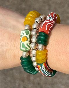 This is a handmade women's stretch bracelet set measuring approximately 6 1/2" in size for a smaller wrist. I made it with African artisan beads that are either glass or brass. Hey, that rhymed. :-) O.k. back to business. :-) This is a three piece stack that can be worn separately or together for a wow factor. The prominent colors are green, yellow and gold. This would be such a fun year round set to add to your bracelet collection or to give as a birthday or anniversary gift. * Each of our jewelry items come in a drawstring jewelry pouch ready for gift giving or for storing. * Note-Different lighting and monitors can vary on hue intensity and shading of beads and beads can vary in the same batch. * Spend $35 or more and receive FREE shipping! African Beaded Bracelets, African Inspired Jewelry, Back To Business, Boutique Style, Inspired Jewelry, Bracelet Collection, African Inspired, Style Gift, Bracelet Stack