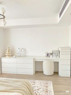 a bedroom with white furniture and decorations on the walls, along with a large rug