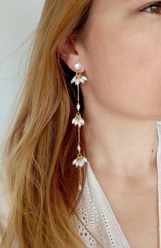 These Boho dangle earrings, with its eclectic and free-spirited aesthetic will captivate the hearts of fashion enthusiasts who cherish uniqueness and elegance. These pearl earring dangles perfectly embody the blend of traditional charm and bohemian flair. These earrings stand out for their ability to add a touch of sophistication to any outfit, making them a versatile accessory for both casual and formal occasions. These Gold dangle earrings have a timeless appeal. The warm hue of gold complemen Elegant Party Jewelry With Dangling Charms, Delicate Pearl Drop Dangle Earrings, Gift Drop Earrings With Dangling Charms, Handmade Elegant Dangle Threader Earrings, Handmade Metal Dangle Bridal Earrings, Dainty Dangling Beads Jewelry For Party, Bohemian Dangle Clip-on Earrings For Wedding, Delicate Dangling Charms Earrings, Elegant Dangling Beads Drop Earrings