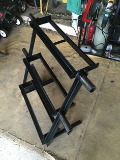 three metal frames sitting on top of a cement floor next to other tools and equipment