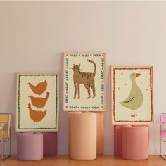 there are three pictures on the wall with animals and birds in them, along with two stools