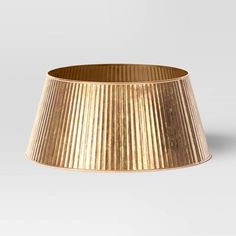 a gold pleated lamp shade on a white background