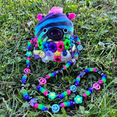 a stuffed animal with colorful beads is laying in the grass