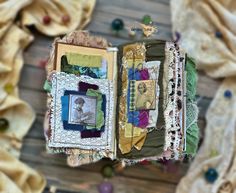 an open book with pictures on it and some beads hanging from the pages, sitting on a wooden surface