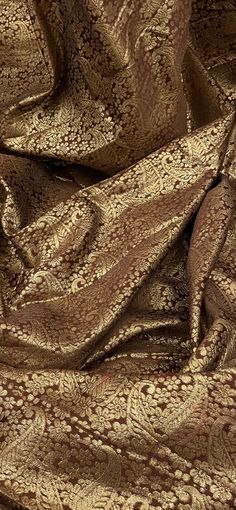 an image of a brown and gold fabric with intricate designs on it's surface