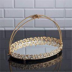 a gold and black basket sitting on top of a table next to a brick wall