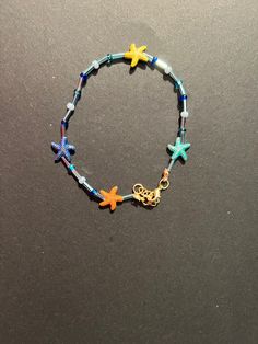 This multicolored starfish anklet has blue beads close to an ocean color. The starfish beads are 14 mm metal. The anklet has a gold clasp closure and an extender. Adjustable Blue Jewelry With Starfish Charm, Adjustable Blue Starfish Jewelry, Blue Starfish Charm Anklet For Summer, Starfish Shaped Beaded Bracelets For Beach, Colorful Beaded Starfish Bracelets For Beach, Blue Anklet With Starfish Charm For Summer, Colorful Starfish Beaded Bracelets For Beach, Blue Anklets With Starfish Charm For Gift, Blue Anklets With Starfish Charm As Gift