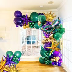 an arch made out of balloons and streamers in the shape of stars, mermaid tailes, and crowns