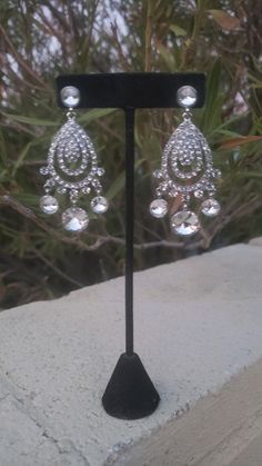 "These fun and stylish rhinestone long chandelier earrings make a statement. Great statement piece! Pageant, prom, or bridal! Size of earrings: 1.5\" wide and 3.5\" Long. Color: Clear Rhinestones Base Metal color: silver Style: Pierced Need a matching bracelet? https://www.etsy.com/listing/767597835/clear-rhinestone-stretch-bracelet?ref=shop_home_active_31 https://www.etsy.com/listing/600792630/clear-rhinestone-bracelet-rhinestone?ref=shop_home_active_67&frs=1 https://www.etsy.com/listing/74 Pageant Earrings, Bridal Statement Earrings, Bridal Earrings Chandelier, Long Chandelier, Bridal Clip, Fun Ornaments, Crystal Chandelier Earrings, Prom Earrings, Rhinestone Bridal