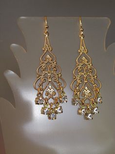 "Swarovski Crystal Filigree Earring Swarovski Crystal rhinestone filigree earrings. These stunning earrings feature large gold plated filigree with Swarovski Crystal rhinestone dangles. Earrings approximate length of 2 1/2\" from top of goldplated earwires and a width of 3/4\" across widest part. Arrives gift boxed. If you are looking for lightweight earrings that make a big statement, these earrings are for you! Perfect for the bride, bridesmaids, or that special occasion - an elegant and timel Bride Earring, Big Earrings Gold, Faberge Jewelry, Gold Filigree Earrings, Bride Earrings, Crystal Dangle Earrings, Earring Gold, Filigree Earrings, Jewelry Fashion Trends