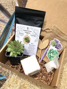 a box filled with plants and soaps on top of a table next to other items