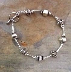 This is a pretty woman's silver bracelet made with sterling silver and silver plated beads.  Of course, because it's silver and neutral, it can be worn with any outfit.  The beads are very interesting, and it's a piece of jewelry you can put on every day. This pretty Woman's silver bracelet could be worn alone or would look great worn with other silver bracelets. 7 1/4 inches long Fun Bracelet, Jewelry Beaded, Toggle Bracelet, Tube Beads, Bracelet Silver, Leather Cord, Silver Bracelets, Bracelet Making, Pretty Woman