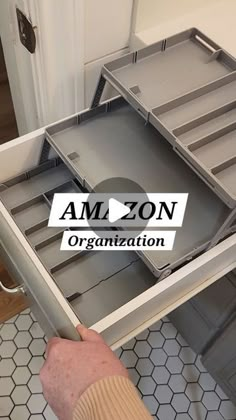 an open drawer with the amazon organization sticker on it and someone's hand