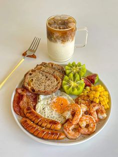 a white plate topped with breakfast foods next to a cup of coffee