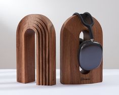 a pair of headphones sitting on top of a wooden stand next to each other