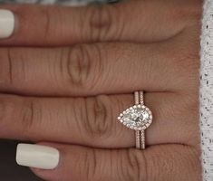 a close up of a person's hand with a diamond ring on their finger