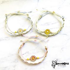 three bracelets with flowers on them sitting on a marble counter top next to each other